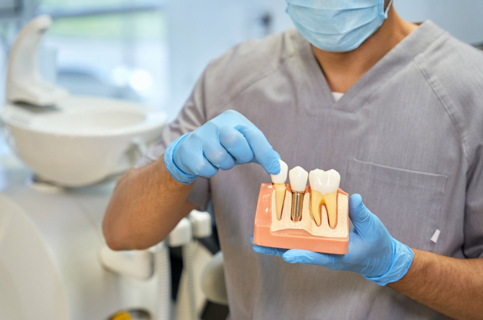 Dentist showing a model of a dental implant
